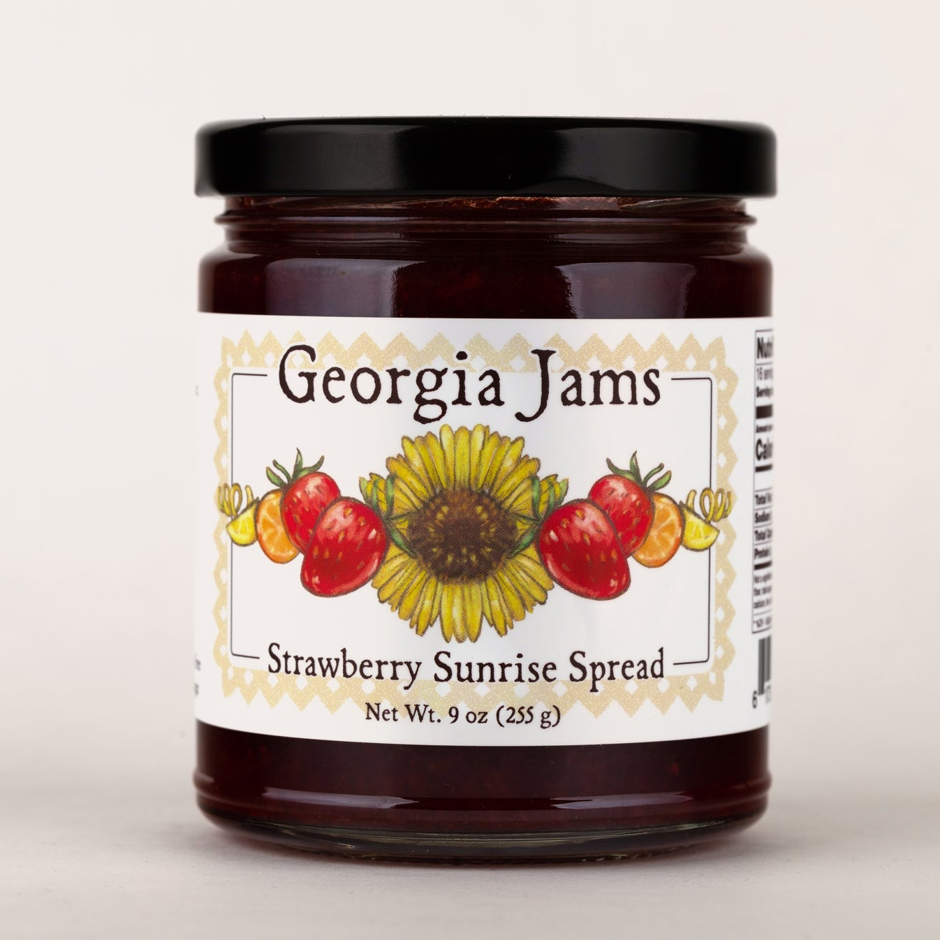 A jar of Georgia Jams Strawberry Sunrise Spread with a label showing strawberries and a sunflower.