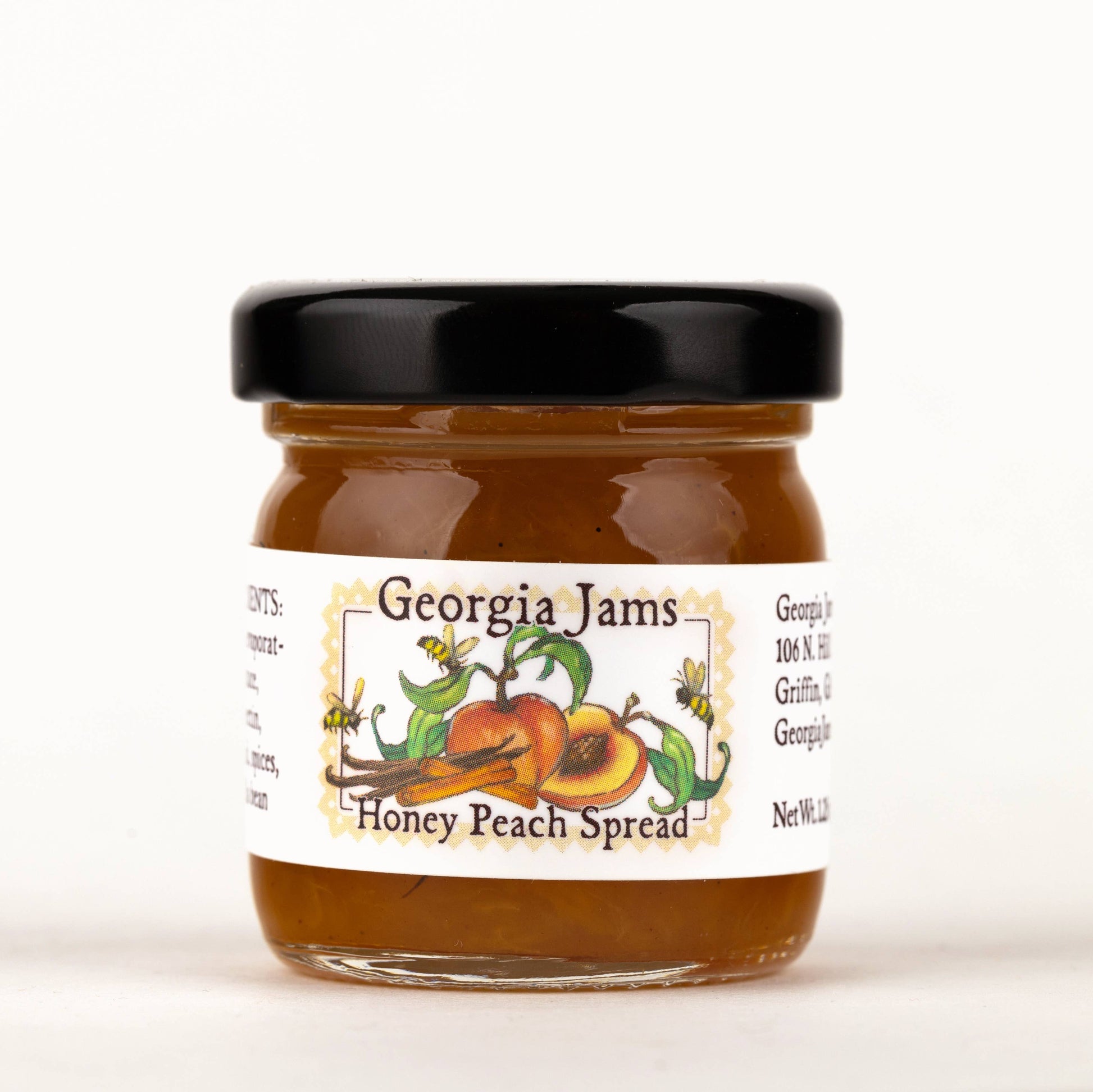 A jar of Georgia Jams Honey Peach Spread with a label showing peaches and the name of the product.
